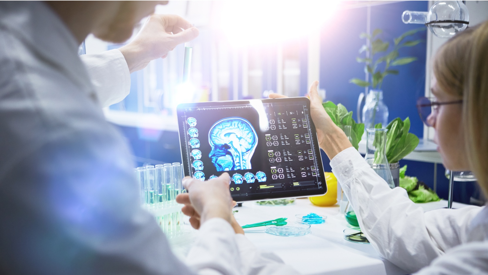 Close up photo of two doctors male and female working in laboratory holding digital tablet and analysing mri scan image.